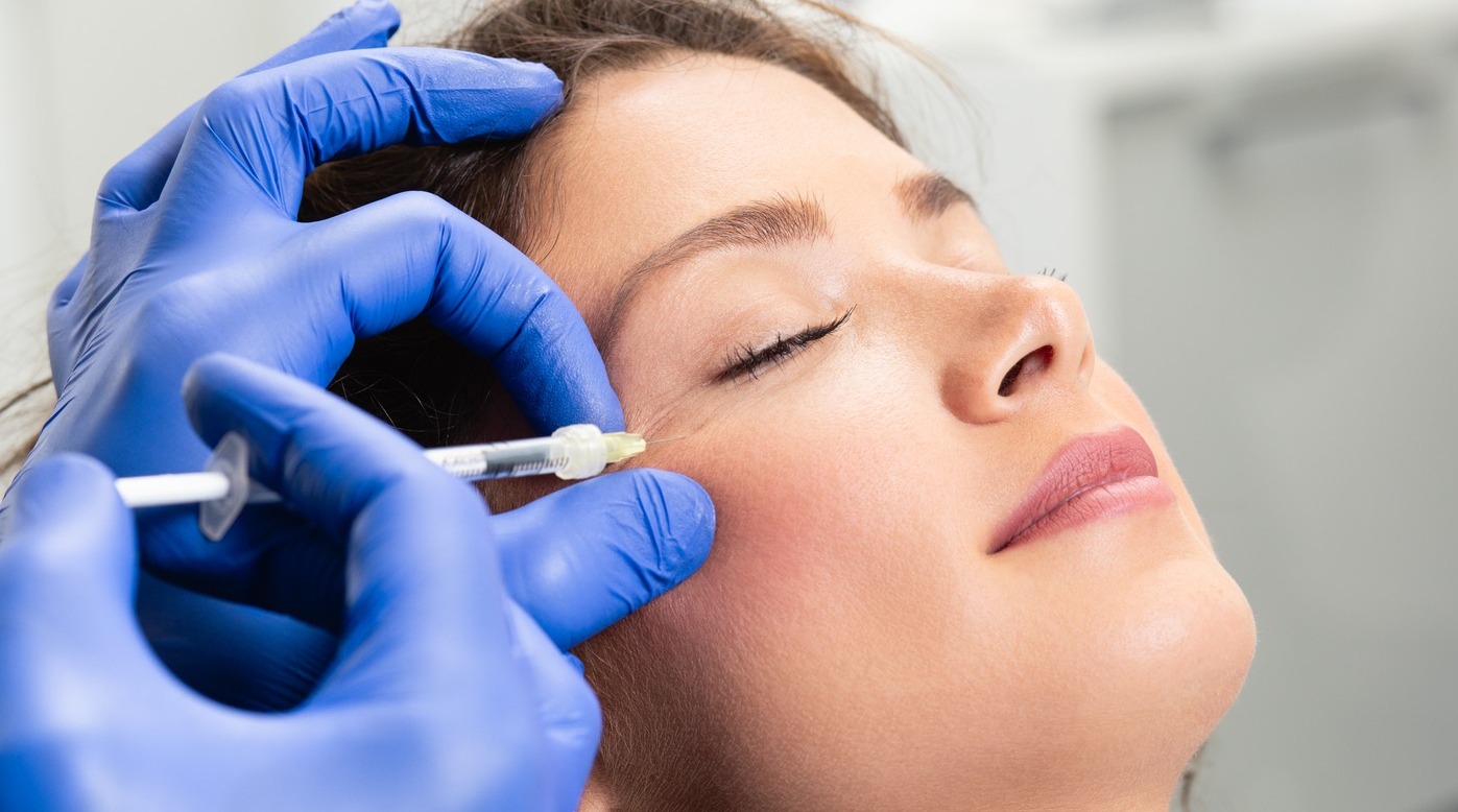 Woman having her crows feet injected.